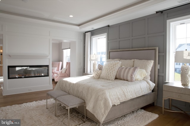 bedroom with hardwood / wood-style flooring and ornamental molding