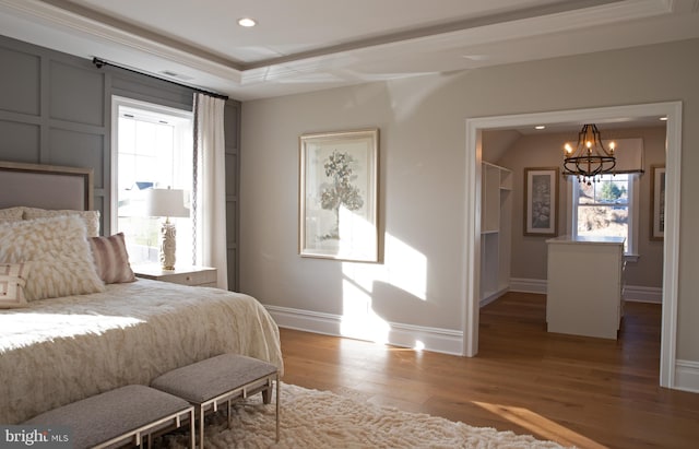 bedroom with ornamental molding, a chandelier, and light wood-type flooring