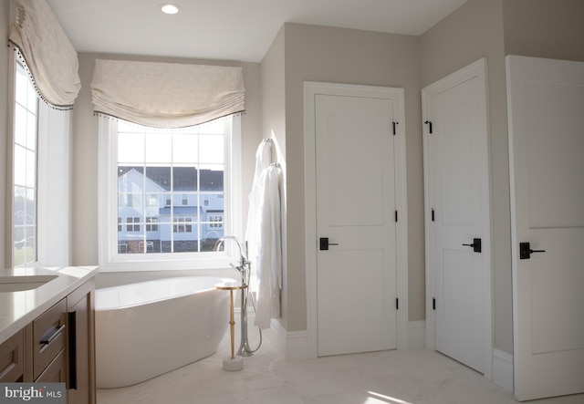 bathroom featuring vanity and a tub to relax in