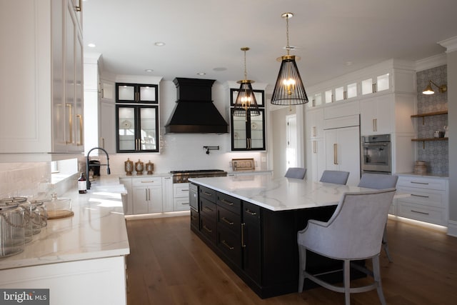 kitchen featuring stainless steel appliances, dark hardwood / wood-style flooring, a spacious island, white cabinets, and custom exhaust hood