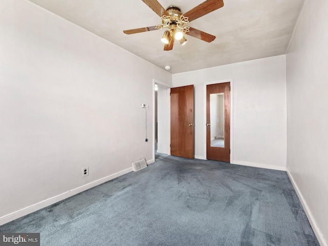 empty room featuring dark carpet and ceiling fan