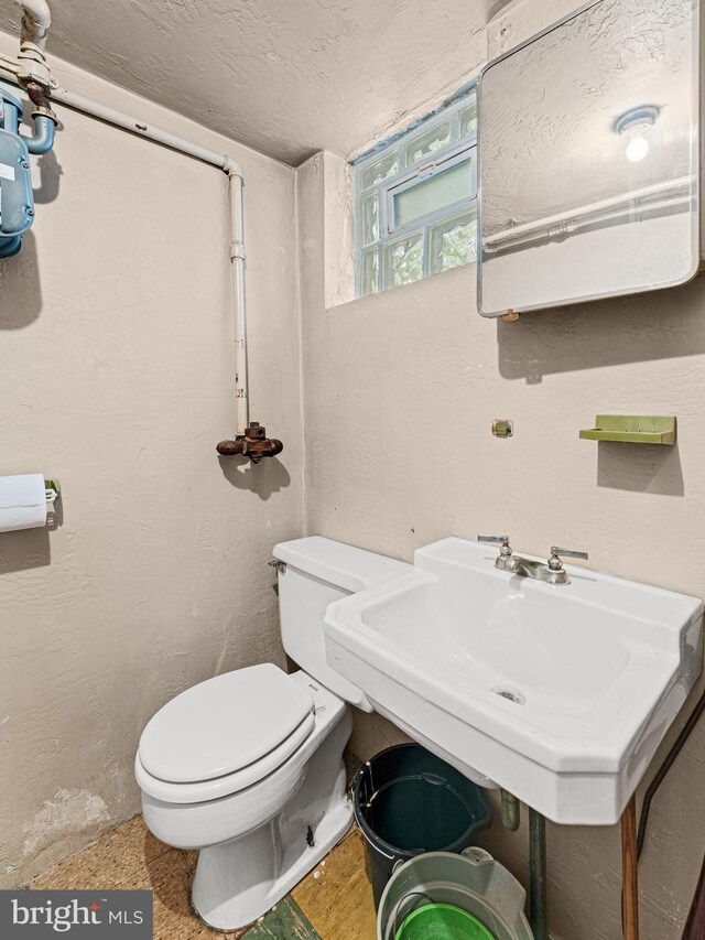 bathroom with a textured ceiling and toilet