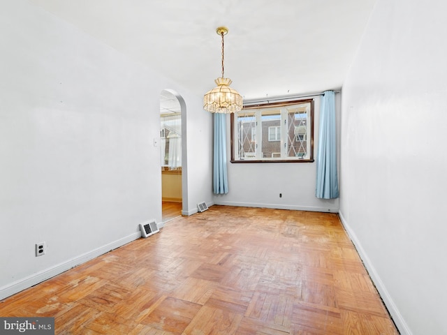 unfurnished dining area with a notable chandelier and light parquet flooring