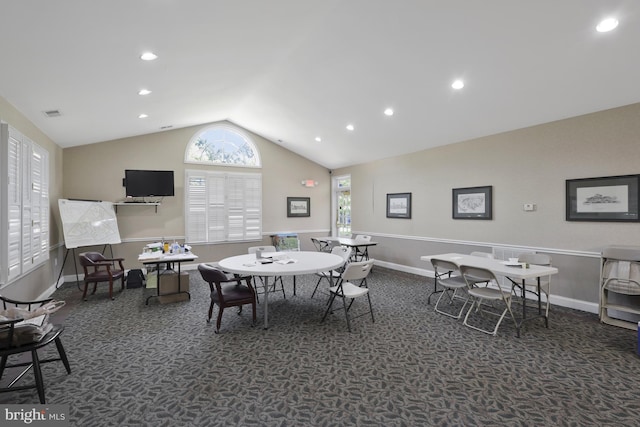 carpeted dining room with vaulted ceiling