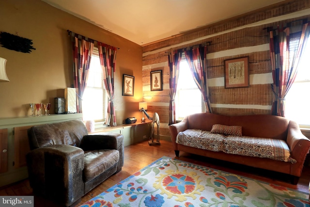 sitting room with wood-type flooring and wood walls