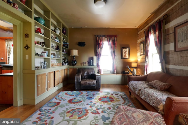 sitting room with light hardwood / wood-style flooring, ceiling fan, and built in features