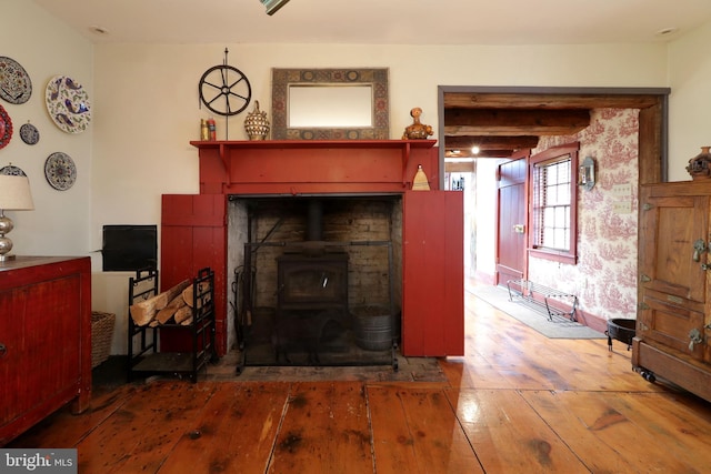 living room with a wood stove and wood-type flooring