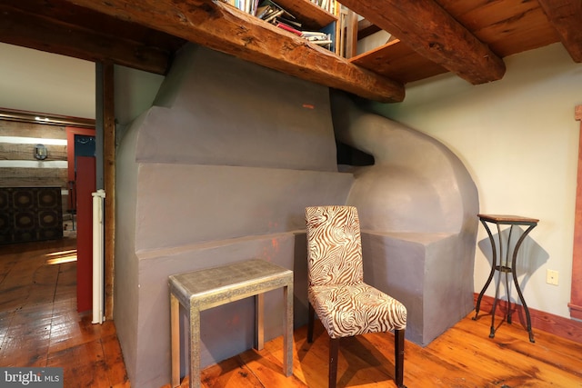 living area featuring wood ceiling, beam ceiling, and hardwood / wood-style floors