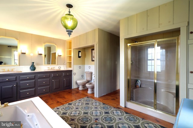 bathroom with walk in shower, vanity, hardwood / wood-style floors, and toilet