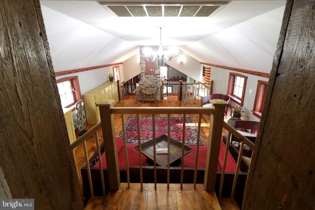 interior space with vaulted ceiling, a chandelier, and hardwood / wood-style floors