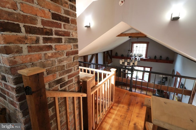 hallway with wood-type flooring and lofted ceiling