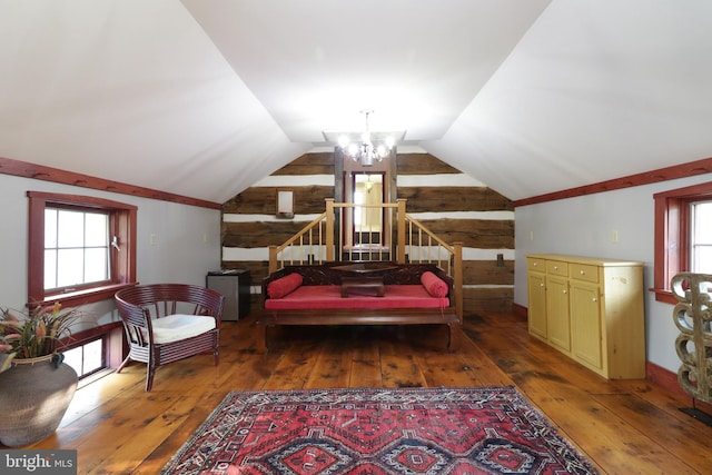 bedroom featuring wood-type flooring, an inviting chandelier, and vaulted ceiling