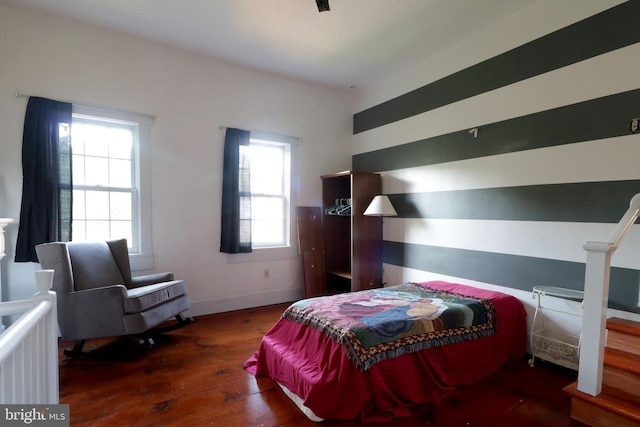 bedroom featuring multiple windows and dark hardwood / wood-style floors