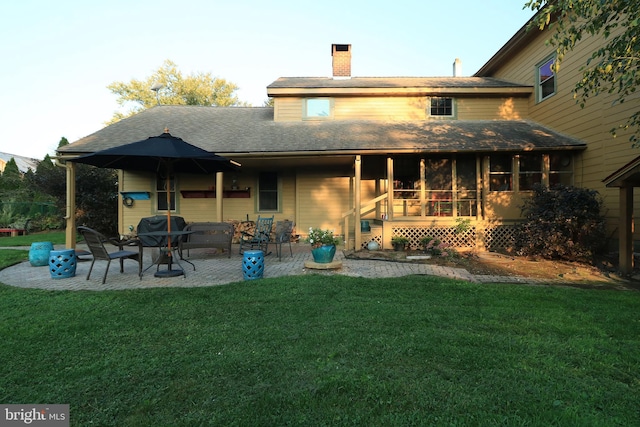 rear view of property featuring a patio and a yard