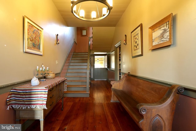 hall featuring an inviting chandelier, lofted ceiling, and dark hardwood / wood-style flooring