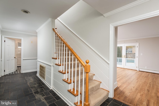 stairway featuring wood-type flooring, ornamental molding, and baseboard heating