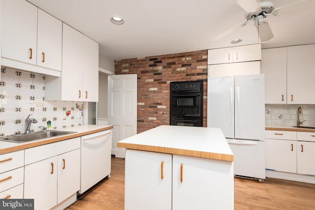 kitchen featuring sink, white appliances, white cabinets, and a kitchen island