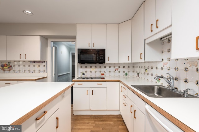 kitchen featuring sink, white cabinetry, and black appliances