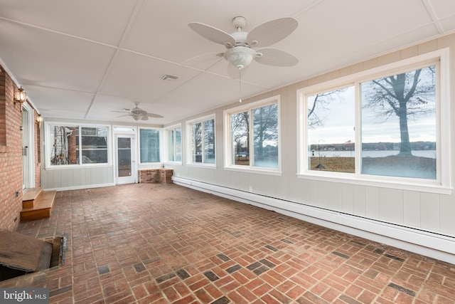 unfurnished sunroom featuring ceiling fan, a water view, and a baseboard heating unit