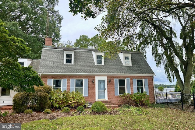 cape cod-style house featuring a front yard