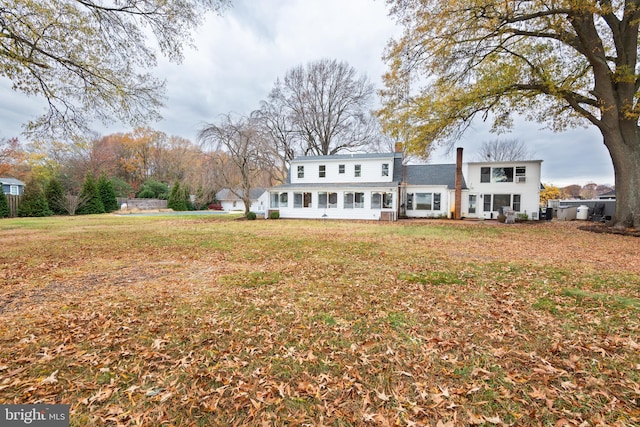 rear view of property featuring a lawn