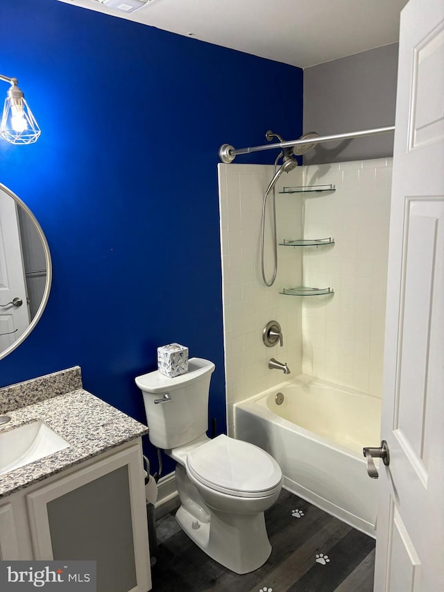 full bathroom with vanity, hardwood / wood-style floors, tiled shower / bath combo, and toilet