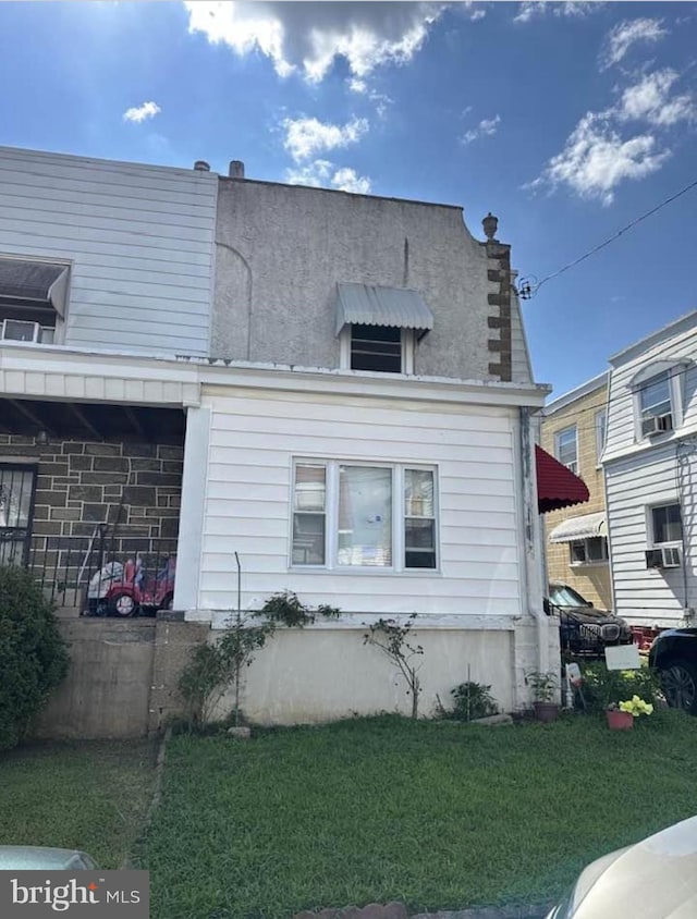 view of side of home featuring cooling unit and a lawn