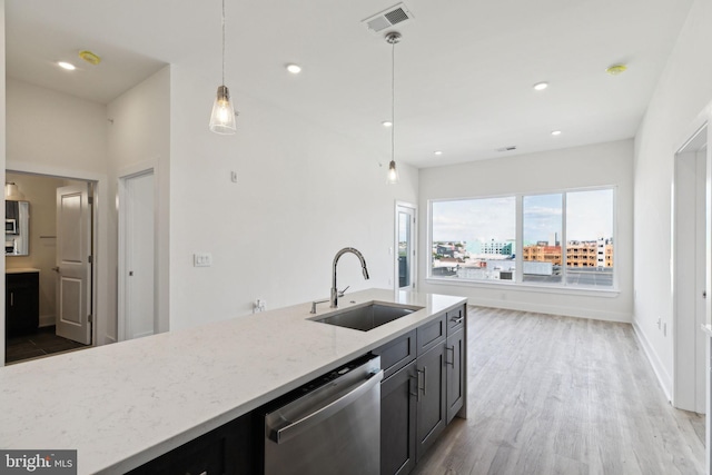 kitchen featuring light stone counters, wood-type flooring, dishwasher, pendant lighting, and sink