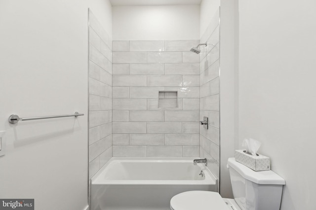 bathroom featuring toilet and tiled shower / bath combo