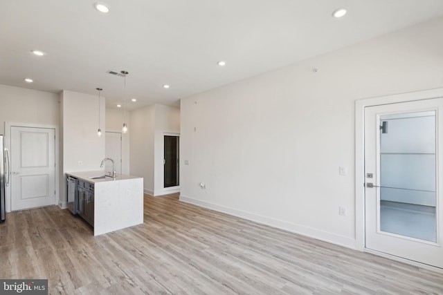 kitchen featuring light hardwood / wood-style floors, appliances with stainless steel finishes, sink, and hanging light fixtures