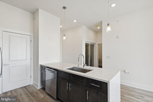 kitchen featuring sink, dishwasher, hanging light fixtures, and light wood-type flooring