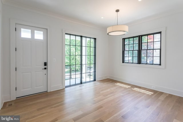 foyer entrance featuring ornamental molding and light hardwood / wood-style floors