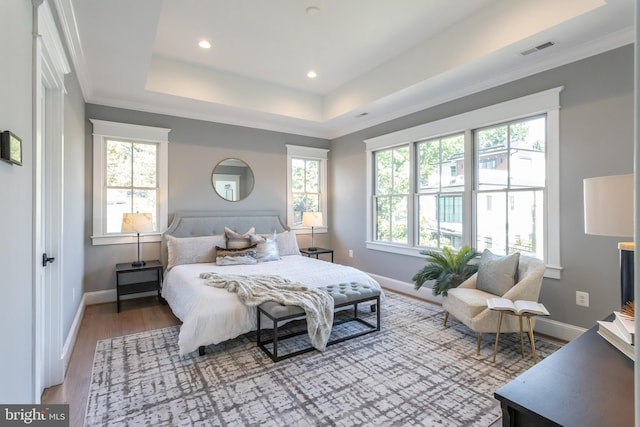 bedroom featuring hardwood / wood-style flooring, multiple windows, and crown molding