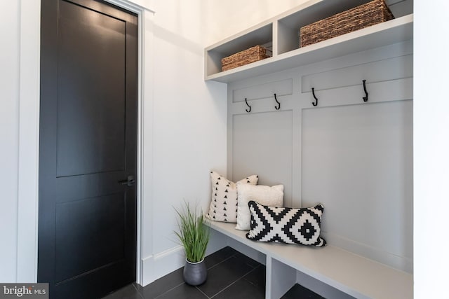 mudroom with dark tile patterned flooring