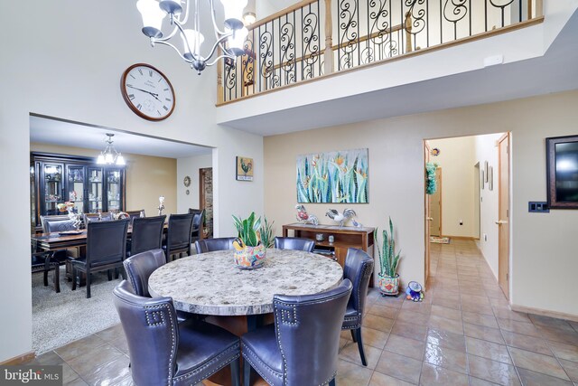 dining room featuring light tile patterned floors, a high ceiling, and a chandelier