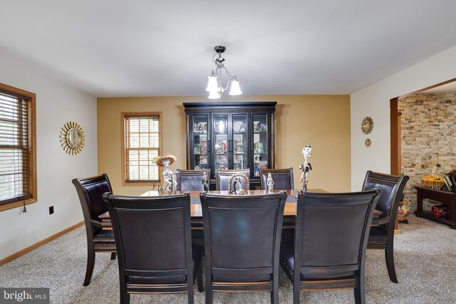 dining space with carpet flooring and a chandelier