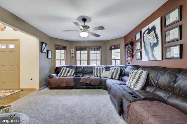 carpeted living room with ceiling fan