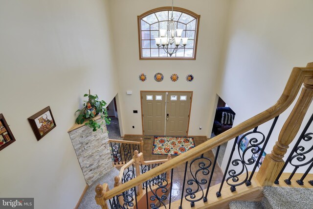 foyer featuring a notable chandelier and a towering ceiling