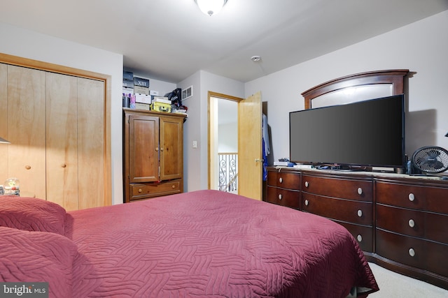 bedroom with light carpet and a closet