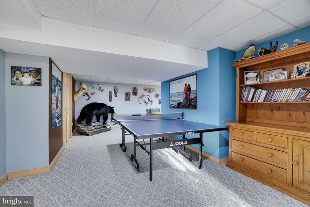 game room featuring a paneled ceiling and light carpet