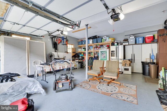 garage featuring a garage door opener and stainless steel fridge with ice dispenser