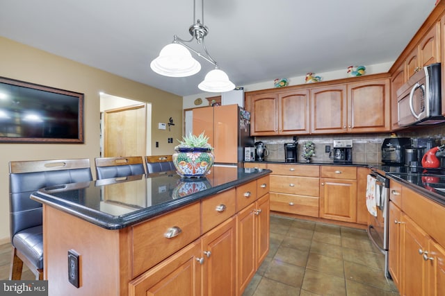 kitchen with appliances with stainless steel finishes, a kitchen island, pendant lighting, and a breakfast bar