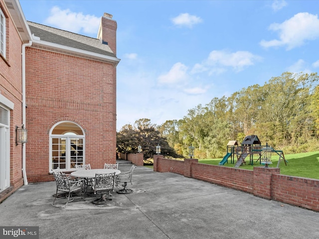 view of patio with outdoor dining space and a playground