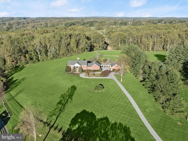 birds eye view of property featuring a forest view