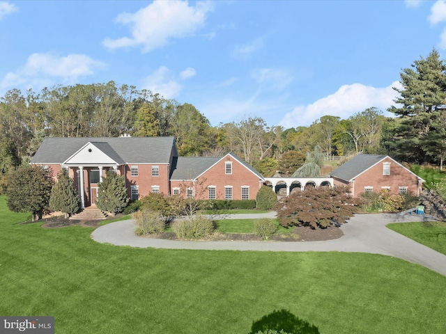 view of front facade featuring driveway and a front lawn