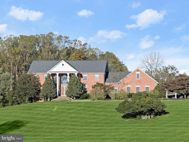 neoclassical / greek revival house with entry steps and a front yard