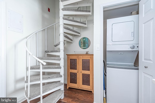 laundry room with stacked washer and dryer and dark hardwood / wood-style floors