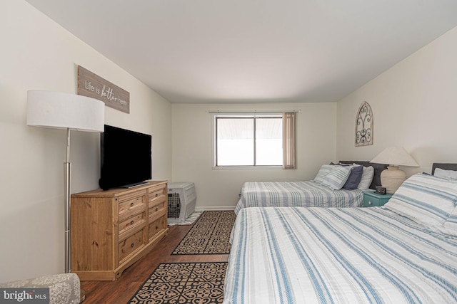 bedroom with baseboards and dark wood-style flooring