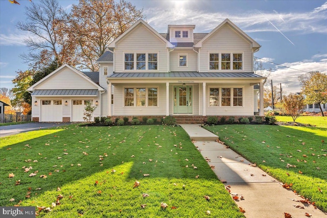 view of front of home featuring covered porch, a front yard, and a garage