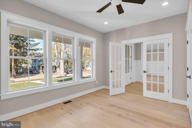 interior space featuring ceiling fan, french doors, and light wood-type flooring